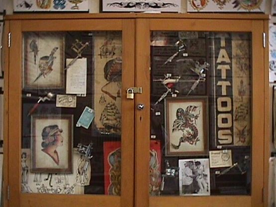 Display case holding various antique machines, Doc Forbes pre-WW II flash, Sailor Pancho "Tattoos window Sign"